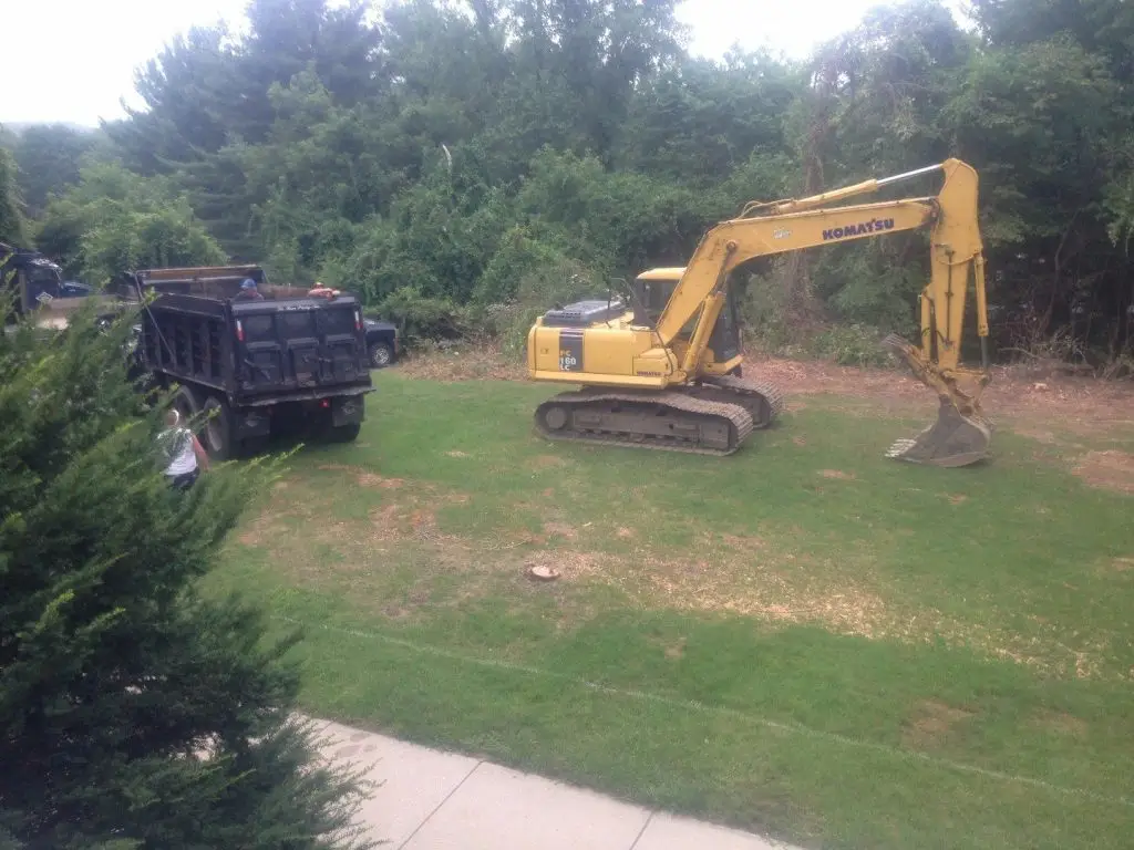 Excavator and dump truck preparing a site for paving